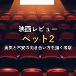 無人の映画館に並ぶ赤いシート、スポットライトが正面のスクリーンを照らす情景。映画レビュー記事全体の雰囲気を表すイメージ。