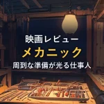 夜のガレージで工具が整然と並ぶ作業台と一灯の照明。映画「メカニック」の周到な準備を思わせるイメージ。